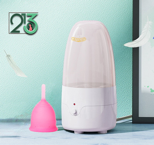 دستگاه استرلایزر با زمینه سازمانی سبز رنگ و یک کاپ صورتی در کنارش