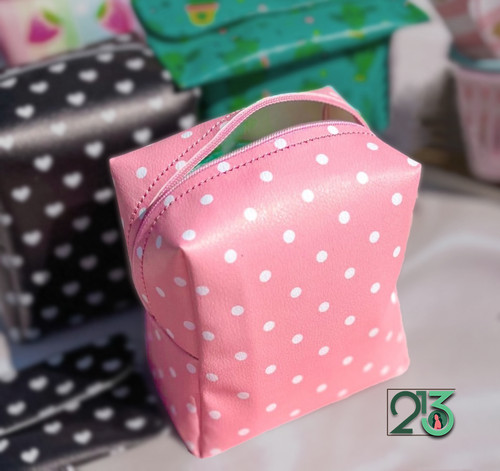 کیف پد صورتی خال خال سفید که رنگ مشکی در پشت تصویر قرار دارد